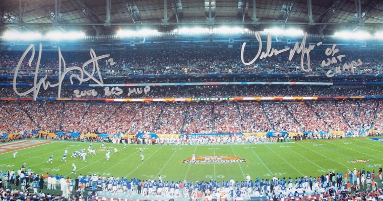 Chris Leak AND Urban Meyer Dual Autographed Florida Gators National Championship 13x39 Panoramic Photo with "2006 BCS MVP" AND "06 NAT CHAMPS" inscriptions ~ 50 Yard line
2006 National Championship Quarterback Chris Leak AND Coach Urban Meyer have both personally hand signed Championship Game Panoramic 13.5 x 39 inch photo with Silver sharpie pens.  Chris added his "2006 BCS MVP" inscription below his signature, which was signed on March 9, 2007.  Coach Meyer added his "06 NAT CHAMPS" inscription below his signature, which was signed on March 14, 2007, in Gainesville, FL.  This item comes with The REAL DEAL Memorabilia deluxe Authenticity, you will receive 1. Two large photos of Chris and Urban signing your type of item, 2. a detailed Certificate of Authenticity, and 3.  Matching REAL DEAL Authenticity Holograms on all items!  You can only get this item through REAL DEAL Authorize distributors, so Get THE REAL DEAL!
Keywords: CLUMP50Yard