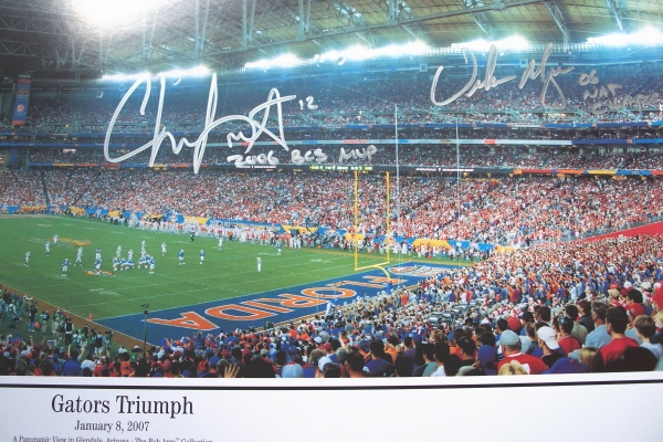 Chris Leak AND Urban Meyer Dual Autographed Florida Gators National Championship 13x39 Panoramic Photo with "2006 BCS MVP" AND "06 NAT CHAMPS" inscriptions ~ Corner End Zone
2006 National Championship Quarterback Chris Leak AND Coach Urban Meyer have both personally hand signed Championship Game Panoramic 13.5 x 39 inch photo with Silver sharpie pens.  Chris added his "2006 BCS MVP" inscription below his signature, which was signed on March 9, 2007.  Coach Meyer added his "06 NAT CHAMPS" inscription below his signature, which was signed on March 14, 2007, in Gainesville, FL.  This item comes with The REAL DEAL Memorabilia deluxe Authenticity, you will receive 1. Two large photos of Chris and Urban signing your type of item, 2. a detailed Certificate of Authenticity, and 3.  Matching REAL DEAL Authenticity Holograms on all items!

Keywords: CLUMPCorner